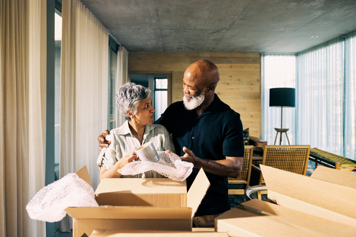 Generation X African-American Couple Unpacking Memories and Smiling in New Home During Retirement Transition