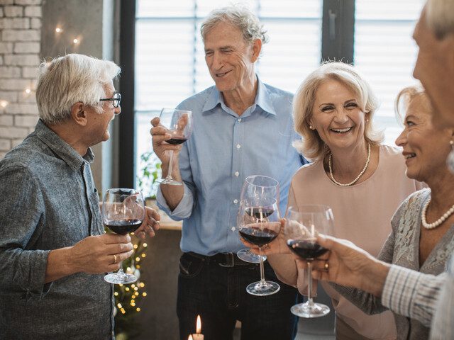 A group of seniors celebrating with wine and snacks